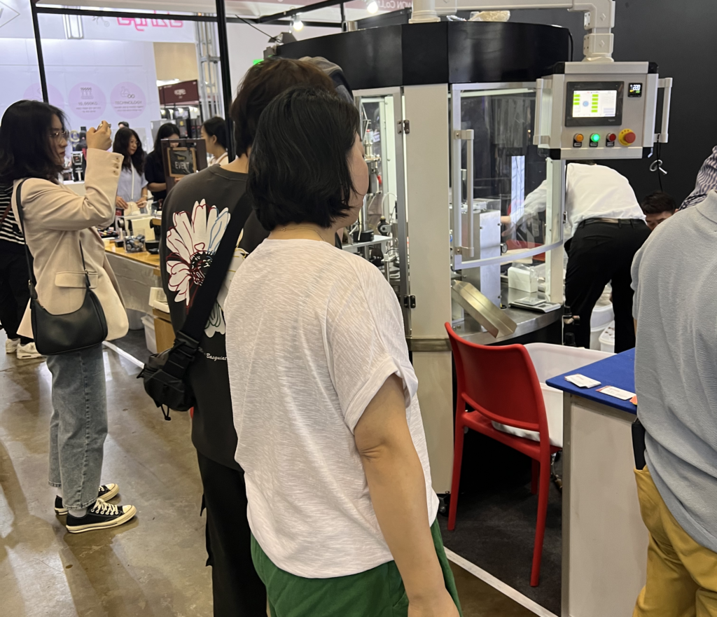 Touristen überprüfen die RN1S-Kaffeekapselfüll- und Verschließmaschine 2